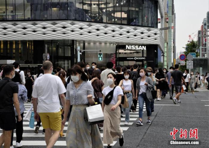 资料图：日本民众佩戴口罩走过东京街头。
/p中新社记者 吕少威 摄